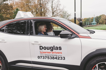 Student and Instructor sitting in a White Douglas Learner Drivers car